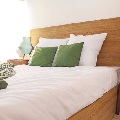 cama elegante con cojines verdes