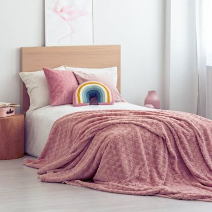 cama decorada con ropa en tonos rosados